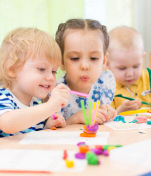 happy kids doing arts and crafts in day care centre